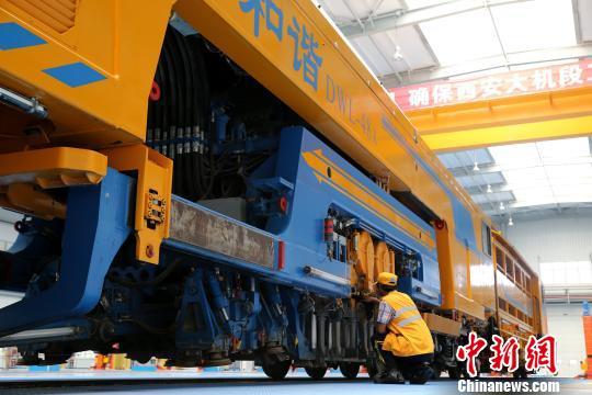 圖為工人正在清理大型養(yǎng)路機(jī)械。　張遠(yuǎn) 攝